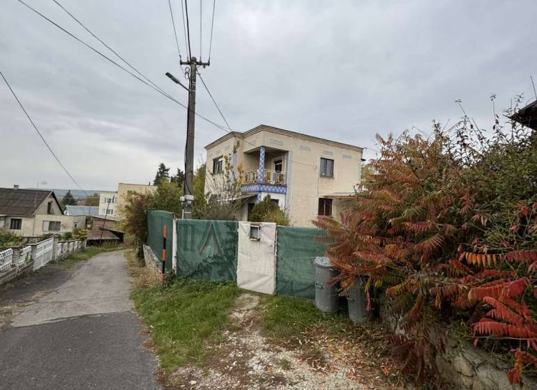 A family house on Gaštanová Street in Vinica surrounded by greenery near an asphalt road.