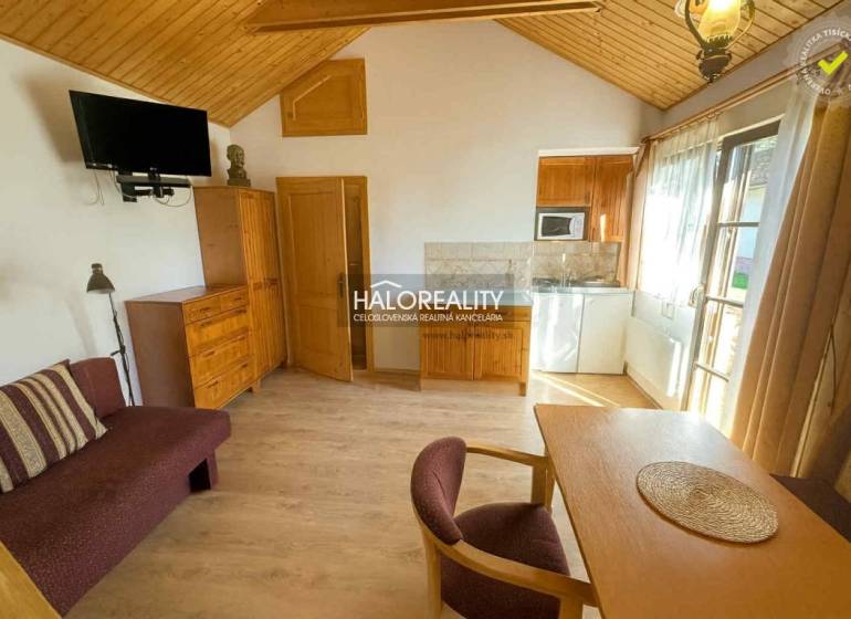 The interior of a cabin with a wooden decor floor, a dining table, and a television.