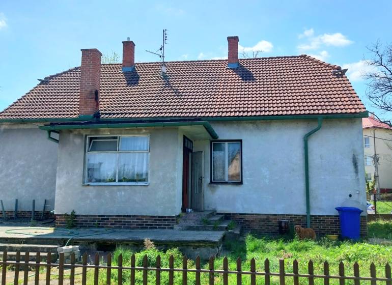 Family house on Štúrova Street, fence, blue container, brick roof.