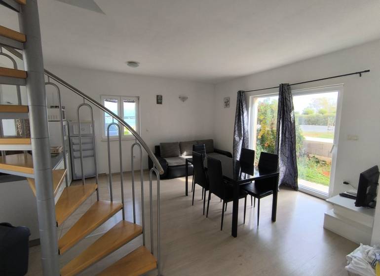 Living room with dining area, spiral staircase, and a view outside in a 3-room apartment.