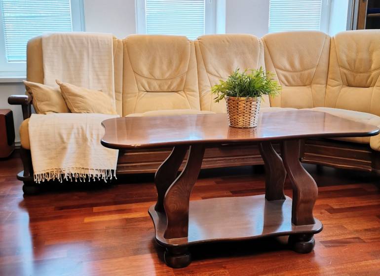 A comfortable sofa set and a table on a floor with a wooden decor in a family house.