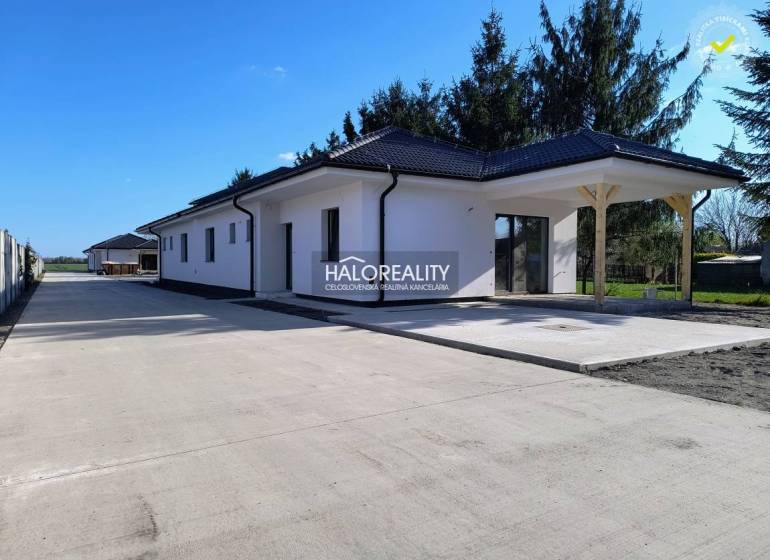 A family house in Blahová with a light facade and a wide adjacent concrete walkway.