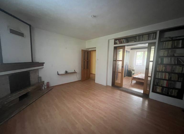 Living room in a family house with a fireplace and a floor with a wooden decor.