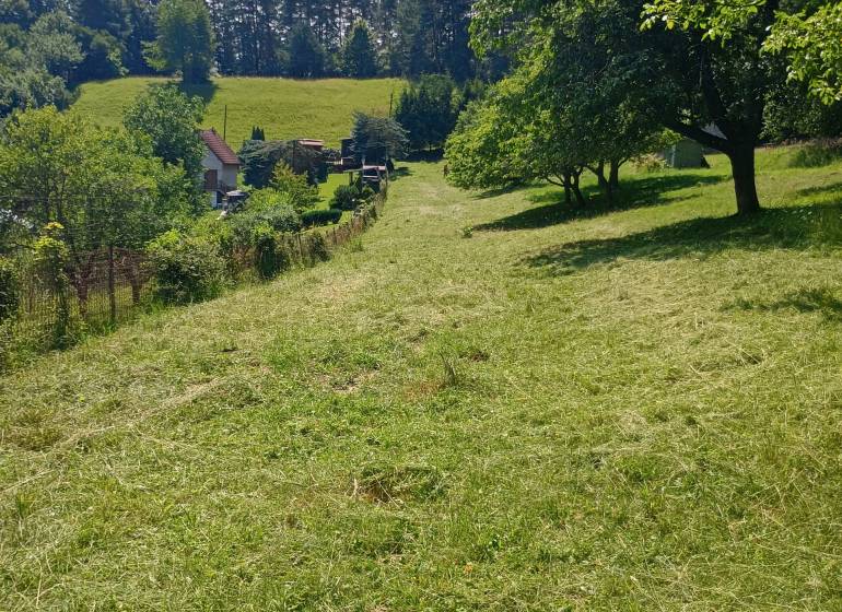 Recreational land in Žilina surrounded by greenery, trees, and a house in the background.
