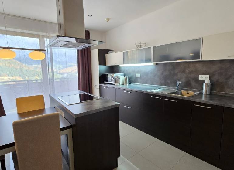Stylish kitchen in a 3-room apartment with a dining table, view, and modern appliances.
