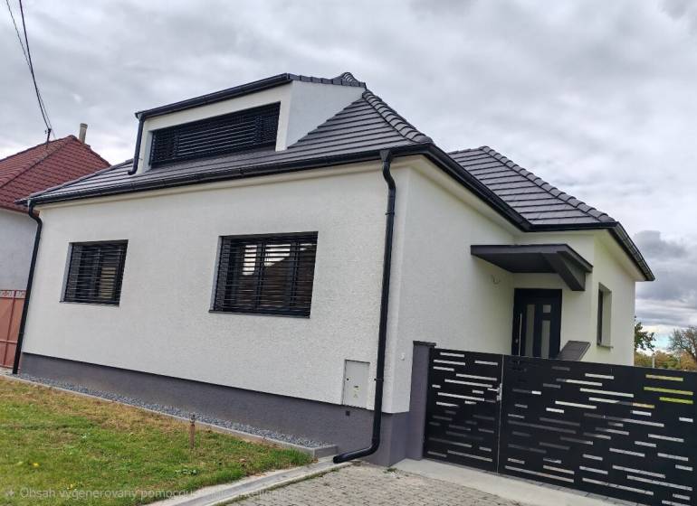 A family house in Jaslovské Bohunice with a white facade and a black roof.
