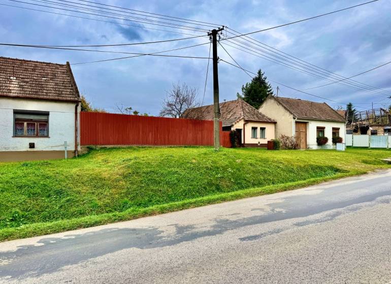 Family houses in Budmerice with grassy gardens and wooden fences.