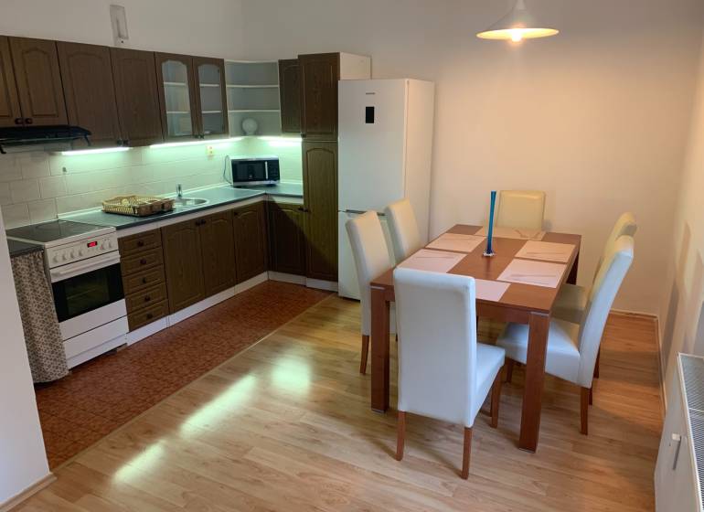 A kitchen with a dining table in a 2-room apartment, floor with wooden decor.