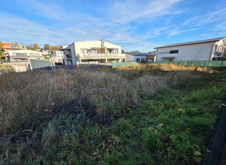 Plots - housing in Bytča with a view of the surrounding houses. Grass and greenery on the area.