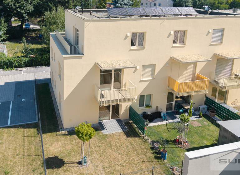Yellow apartment building on Železničná Street in Bratislava-Vrakuňa with a garden and parking spaces.