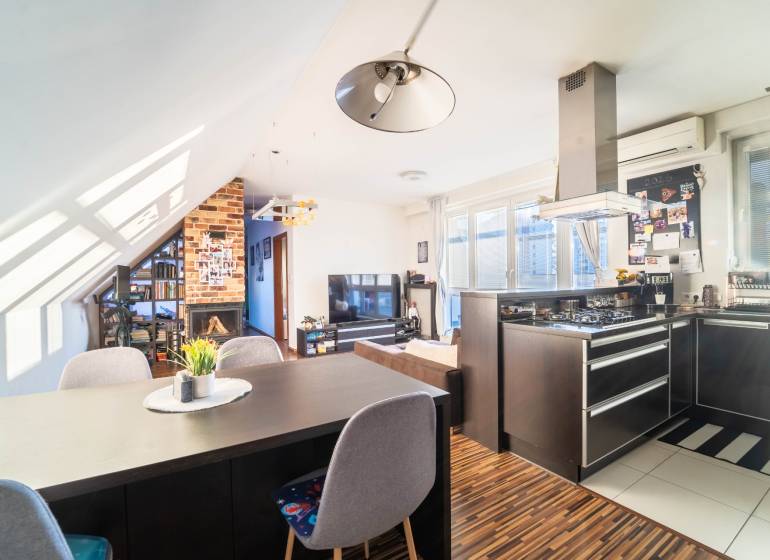 A kitchen with a TV, fireplace, and wooden decor flooring in a 2-room apartment.