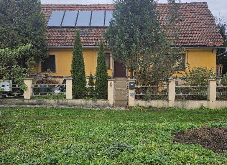 A family house on Sapietová Street in Gbeľany, surrounded by greenery with large windows on the roof.