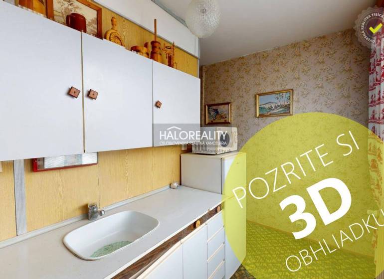 A kitchen in a 3-room apartment with white cabinets and pictures on the walls.