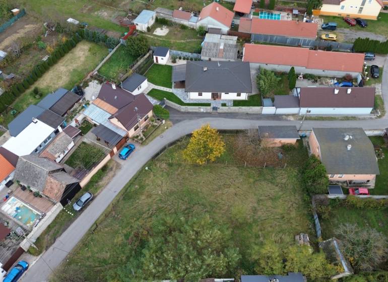 Aerial view of residential plots in Gajary with adjacent road and houses.
