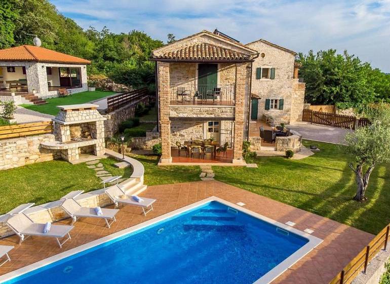 Villa in Bale with a garden, swimming pool, sun loungers, and a stone fireplace.