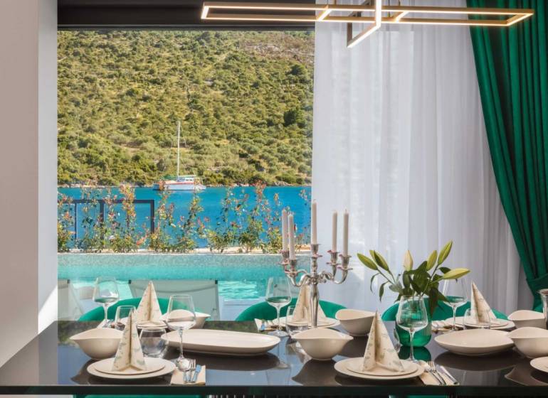 Elegant dining with a view of the pool and the sea in the villa.