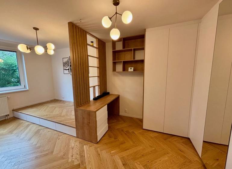 Interior of a 2-room apartment with a wooden decor floor and minimalist lighting fixtures.