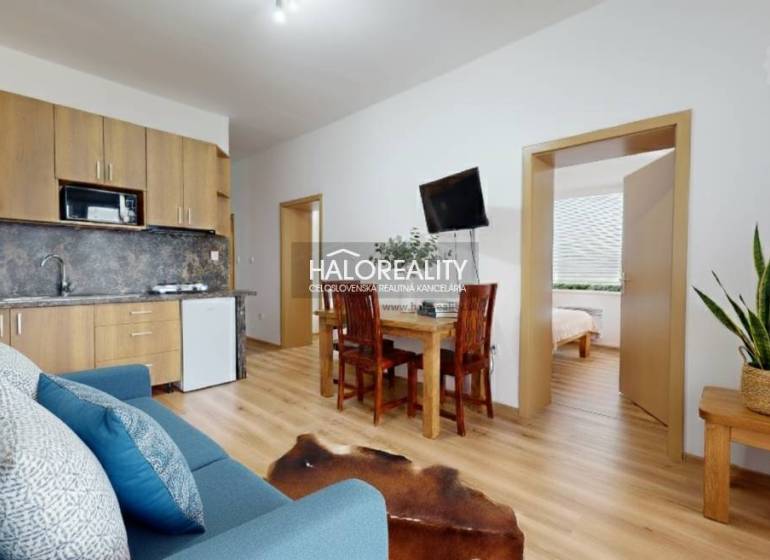 Living room of a 3-room apartment with a wood-patterned floor and comfortable seating.