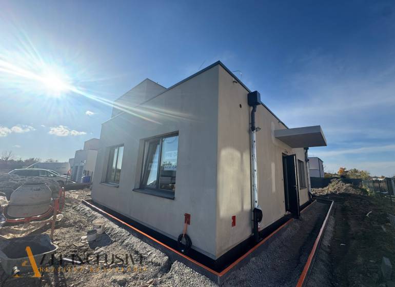 The exterior of a family house in Hubice during construction, sunny weather brightens the scene.