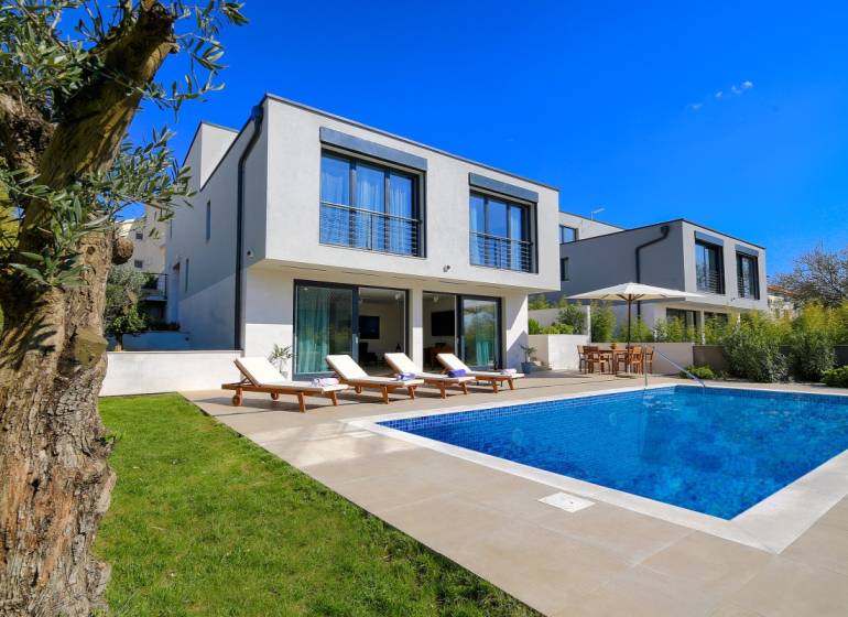 A villa in Bale with a swimming pool, sun loungers, and a garden for relaxation.