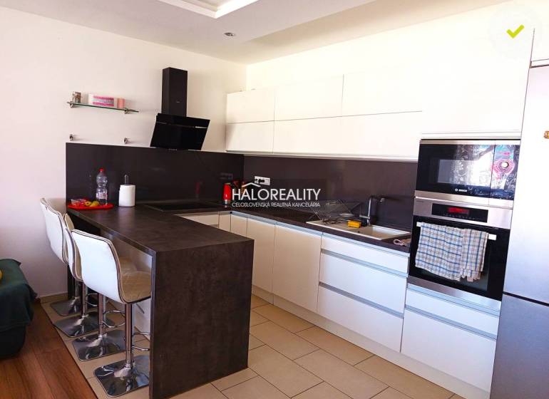 A kitchen with white cabinets and a bar counter in a 3-room apartment.