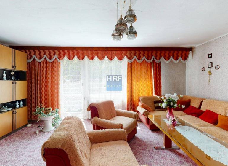 Living room in a family house with orange curtains and stylish furnishings.
