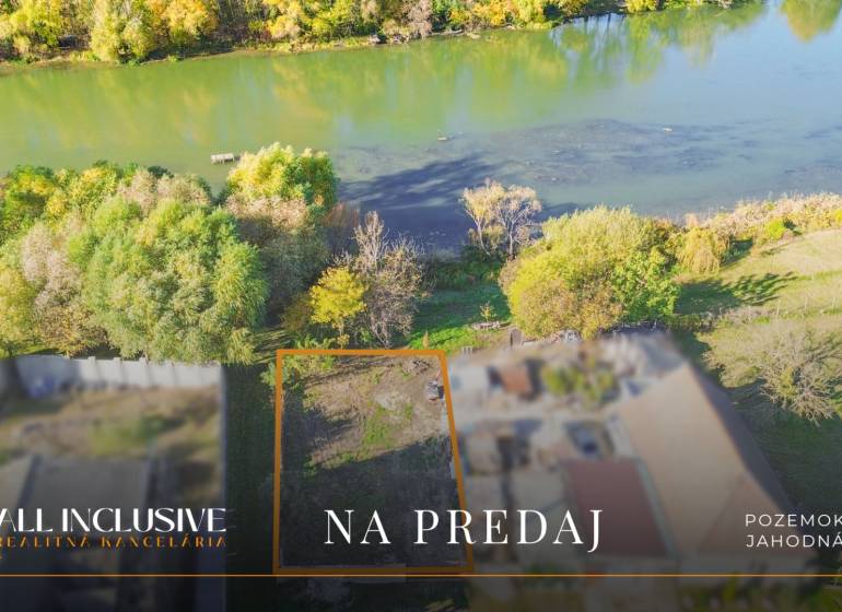 Land for sale by the river in Jahodná, surrounded by greenery and trees.