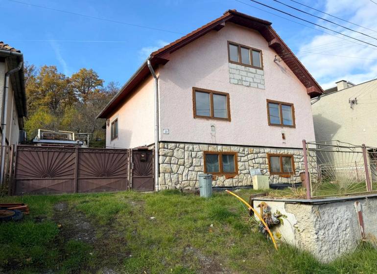 A family house in Stará Kremnička with a sloping garden and a stone facade.