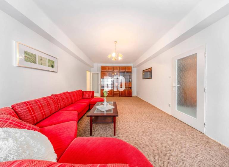 Red sofa, glass table, built-in cabinet, and light carpet in a 4-room apartment.