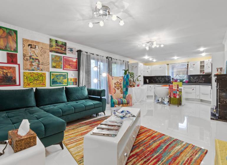Colorful living room in a family house with a sofa, an armchair, and art on the walls.