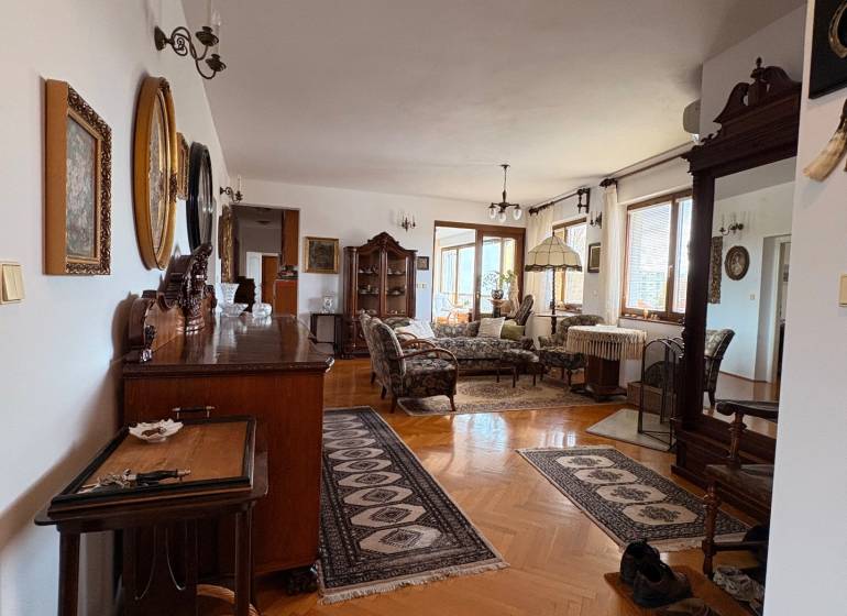 A 5 or more bedroom apartment with wood-patterned flooring, classic furniture, and carpets.