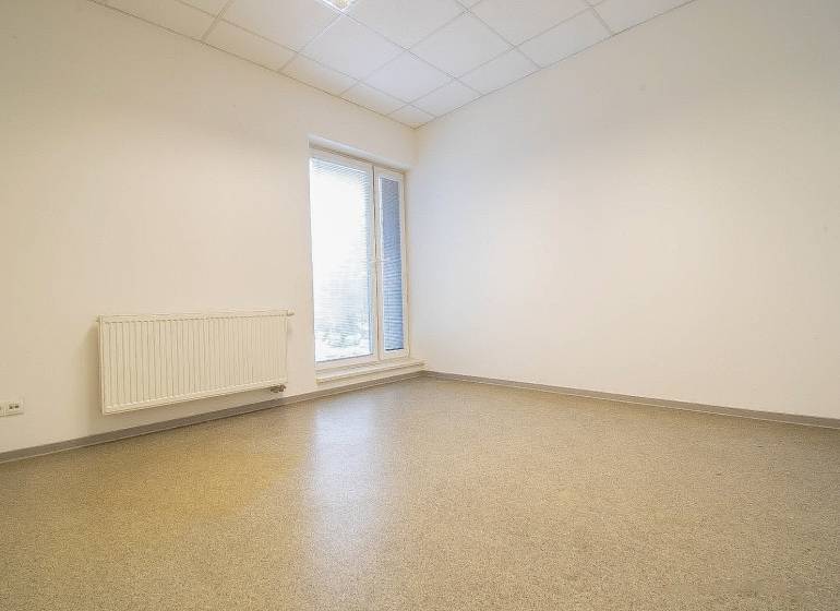 Empty office with a window, radiator, and floor.