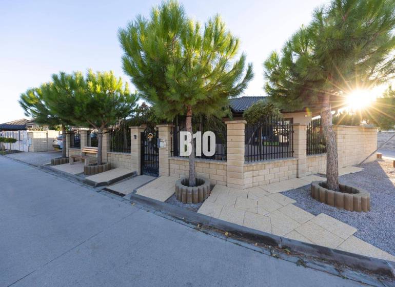 A family house in Most pri Bratislave with a stone fence and tree planting.