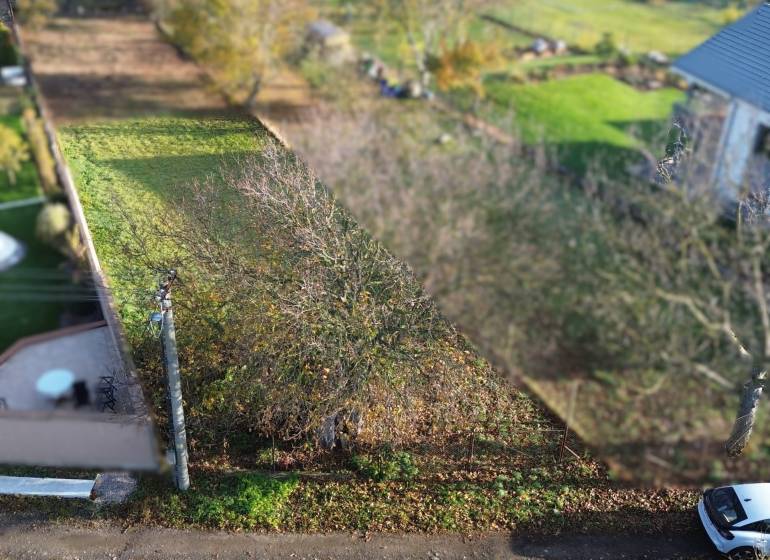 A residential plot in Dolná Krupá on M.H. Chvoteková surrounded by greenery and trees.