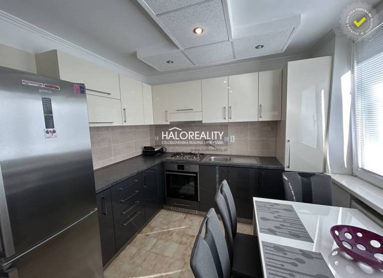 A kitchen in a 2-room apartment with a wood-patterned floor and light cabinets.