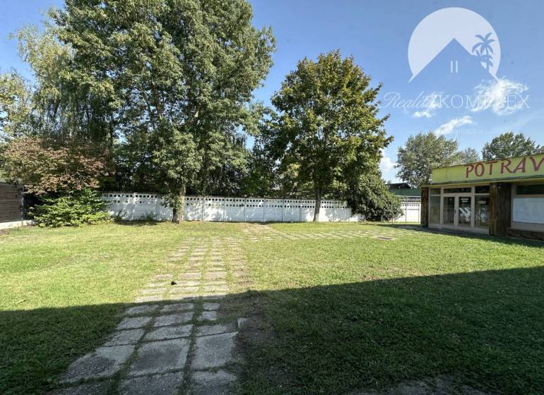Commercial premises in Patince with a lawn and trees, groceries close to the left side.