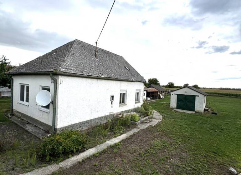 A family house in Komárno with an adjacent lawn and a satellite dish on the facade.