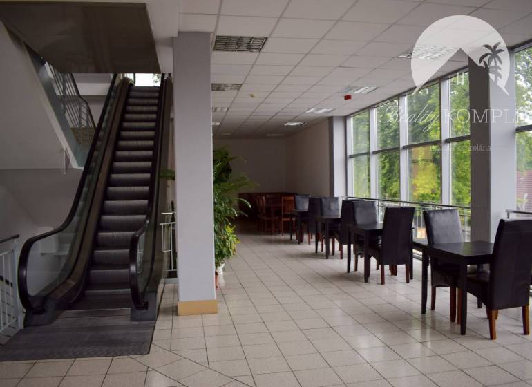 Commercial space with an escalator and tables, ideal for offices or a relaxation zone.
