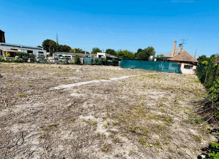 A plot for residential use in Veľký Meder with a view of the surrounding architecture.