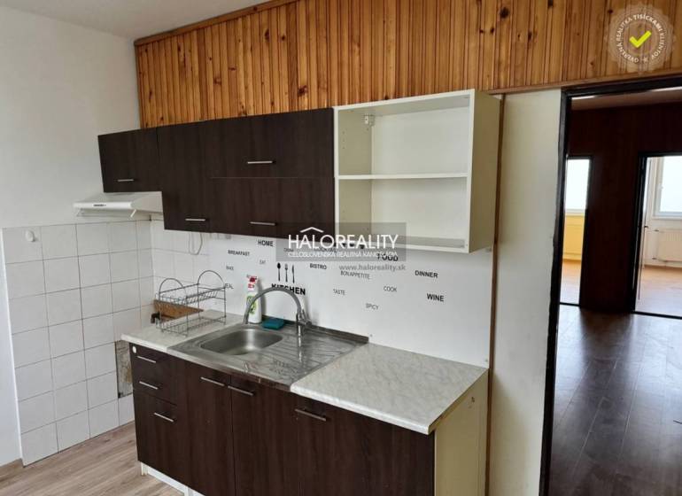 A kitchen in a 4-room apartment with white and dark cabinets, and a floor with a wood decor.