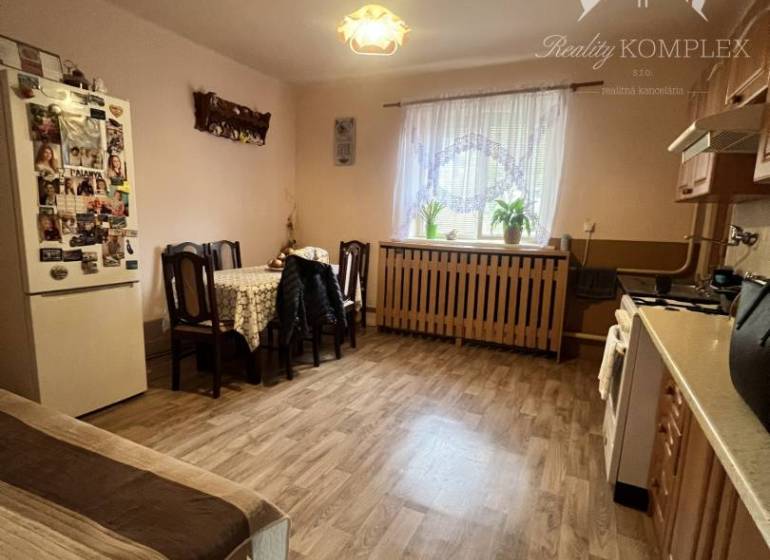 A kitchen in a family house with a wooden decor floor, a table, and a sofa set.