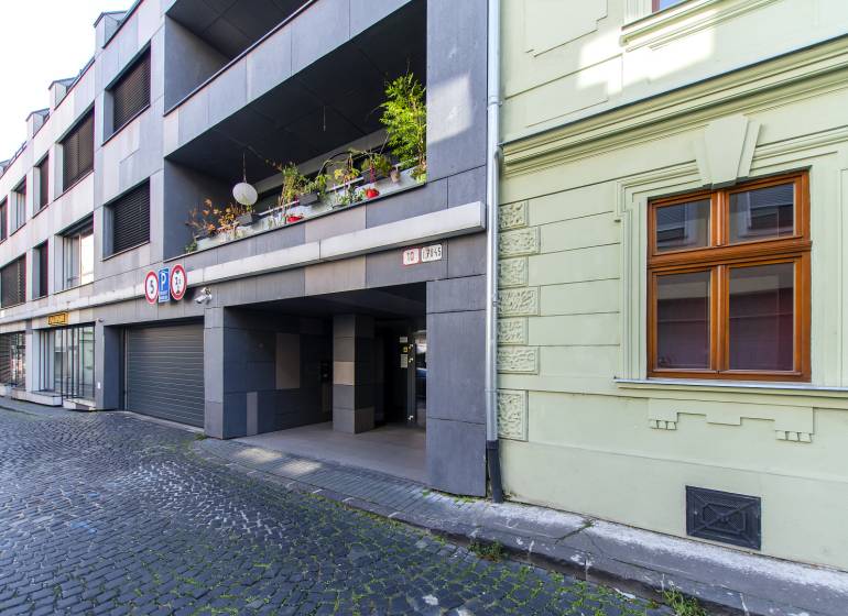 Garages on Jozefská Street in Bratislava - Old Town with stone cladding and vegetation.