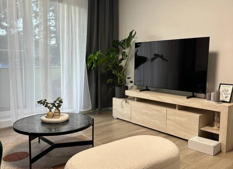 Living room in a three-room apartment with a wooden decor floor and stylish furniture.