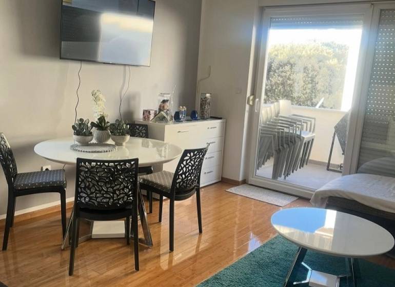 Living room of a three-room apartment with a wooden decor floor and a balcony.