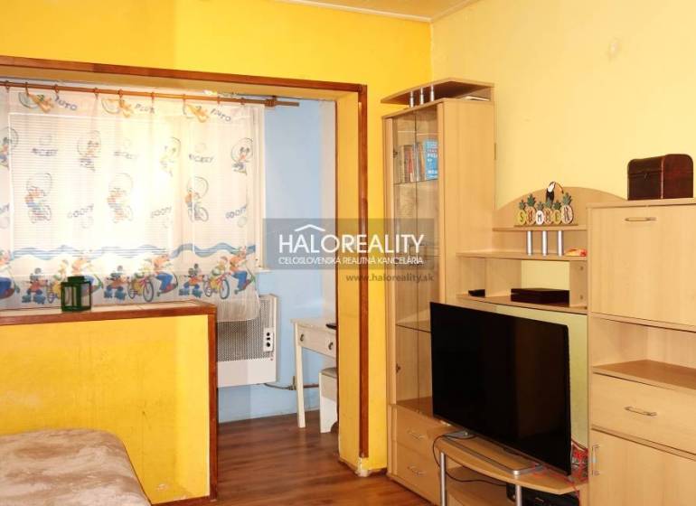 Interior of a 1-room apartment with a wooden decor floor and yellow walls.