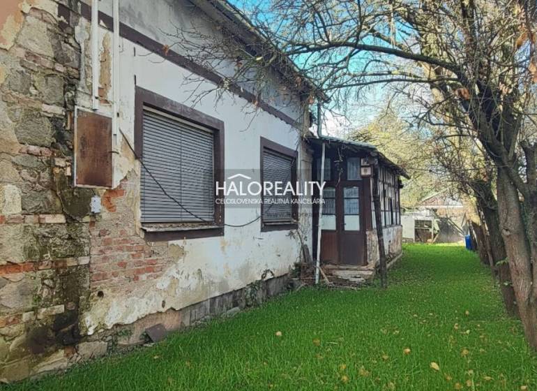 A family house in Rimavská Sobota, with significant signs of wear and a tree in the garden.