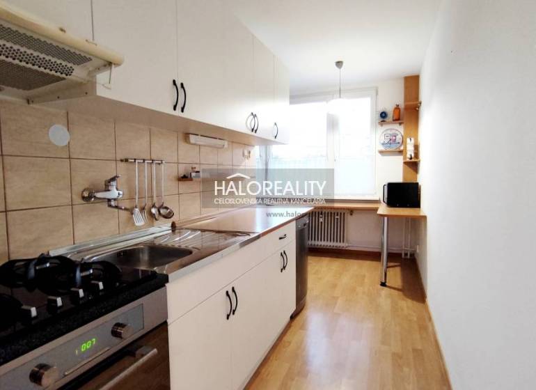 Kitchen and 2-room apartment with white cabinets, a gas stove, and a large window.
