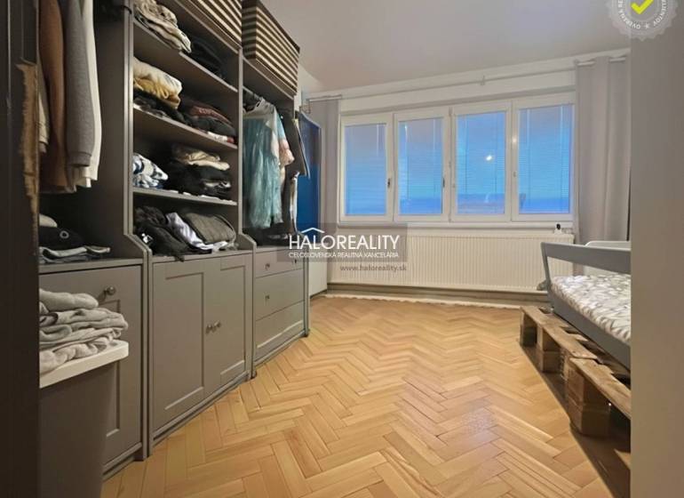 A room with a wooden floor decor, a wardrobe, and a children's bed.