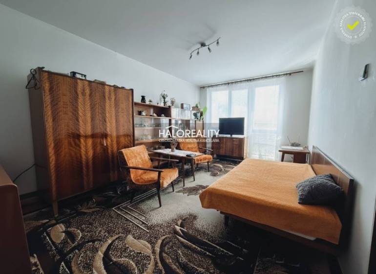 Living room in a 3-room apartment with retro furniture and a carpet, bright lighting.