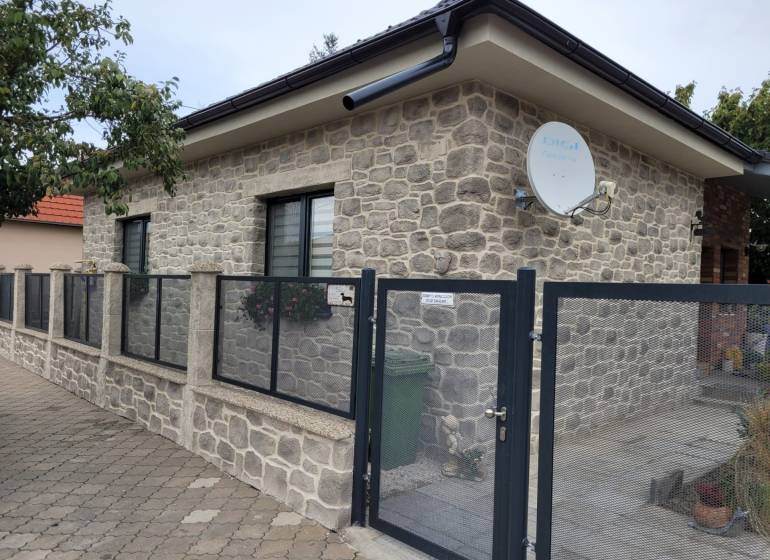The family house in Okoličná na Ostrove has a stone facade and a satellite dish.